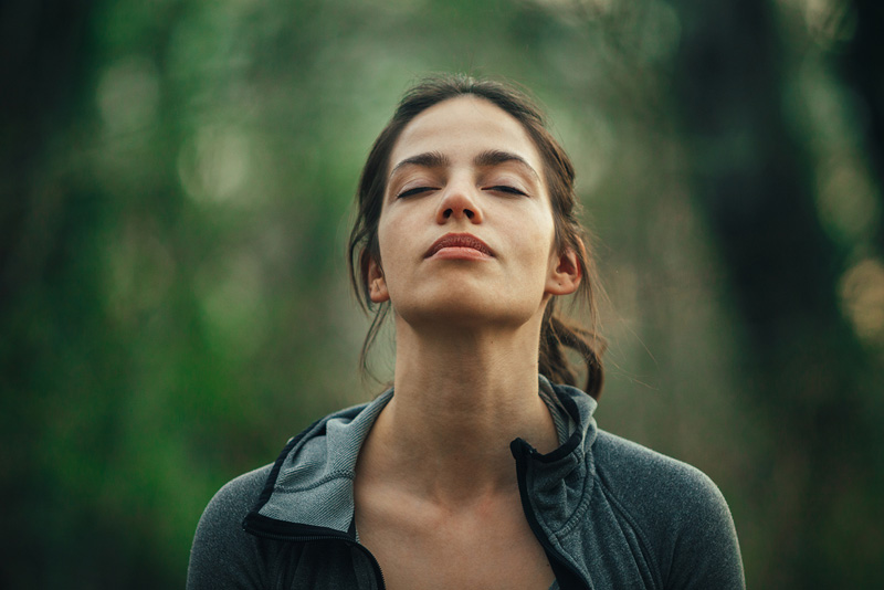 Eine Frau hebt entspannt ihren Kopf