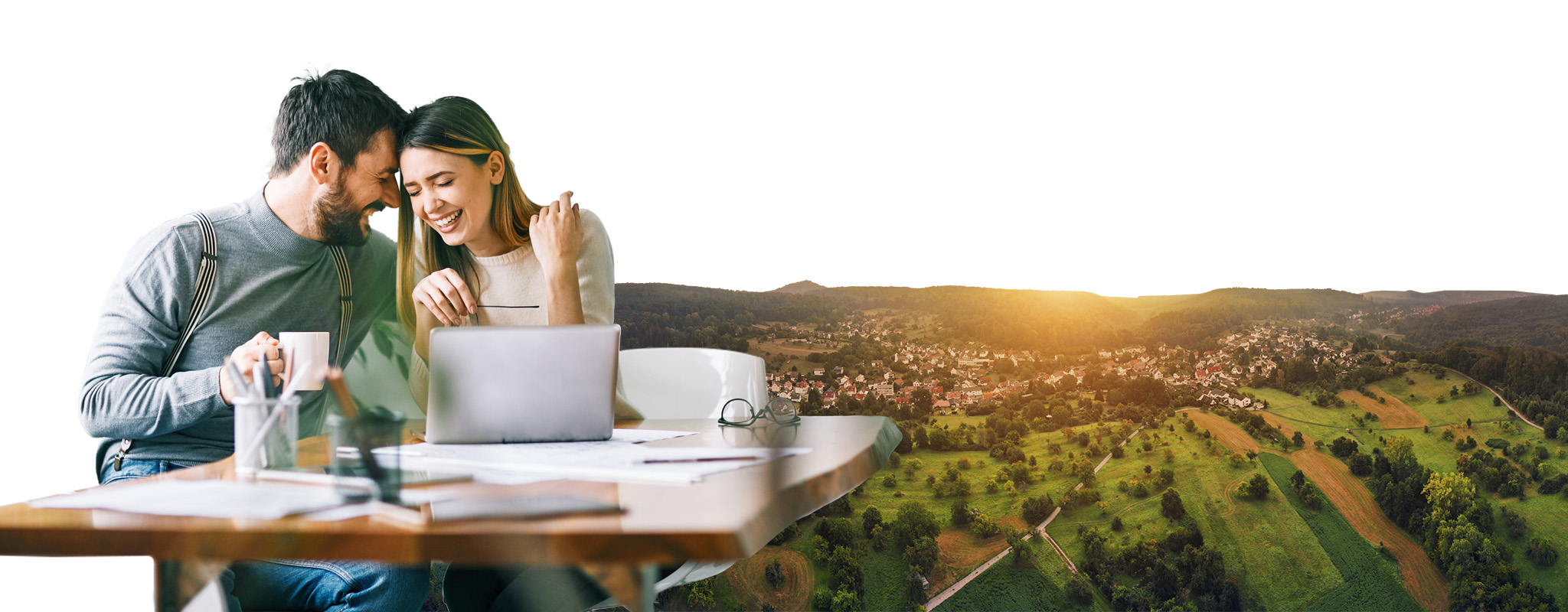 Ein Paar sitzt lachend vor einem Laptop