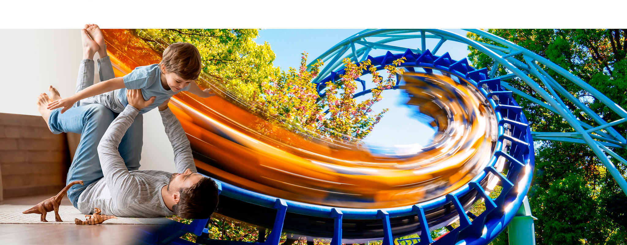 Vater hebt seinen Sohn in die Luft, daneben Achterbahn in voller Fahrt